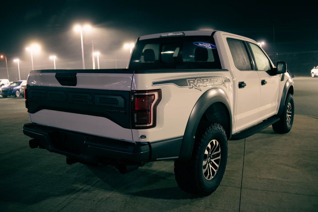 New pickup parked against cars at night